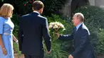 Presiden Rusia Vladimir Putin (kanan) berlutut memberi bunga kepada istri Presiden Prancis Emmanuel Macron (tengah), Brigitte Macron (kiri) di Benteng Bregancon, Bormes-les-Mimosas, Prancis, Senin (19/8/2019). Putin diketahui kerap memberi bunga kepada wanita. (Gerard Julien, Pool via AP)