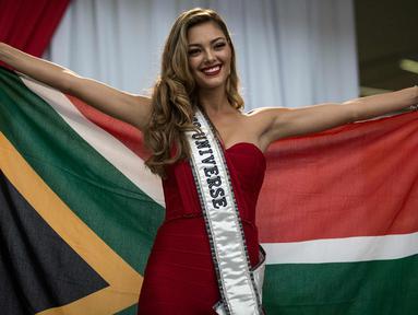 Miss Universe 2017 Demi-Leigh Nel-Peters berpose dengan bendera Afrika Selatan saat tiba di Bandara Internasional OR Tambo di Johannesburg (24/1). Untuk pertama kalinya setelah dinobatkan Demi Leigh baru pulang ke Afrika Selatan. (AFP Photo/Gulshan Khan)
