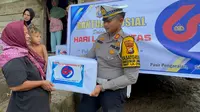 Kasat Lantas Polres Rokan Hulu AKP Tatit Rizkyan Hanafi SIK menyerahkan bantuan sembako kepada salah satu korban banjir. (Liputan6.com/M Syukur)