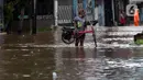 Warga mengangkat sepedanya saat melewati banjir yang menggenangi kawasan Jalan Wolter Monginsidi Jakarta dan sekitarnya, Sabtu (20/2/2021). Hujan yang mengguyur Jakarta sejak Jumat (19/2) membuat sejumlah titik di Jakarta terendam banjir. (Liputan6.com/Helmi Fithriansyah)