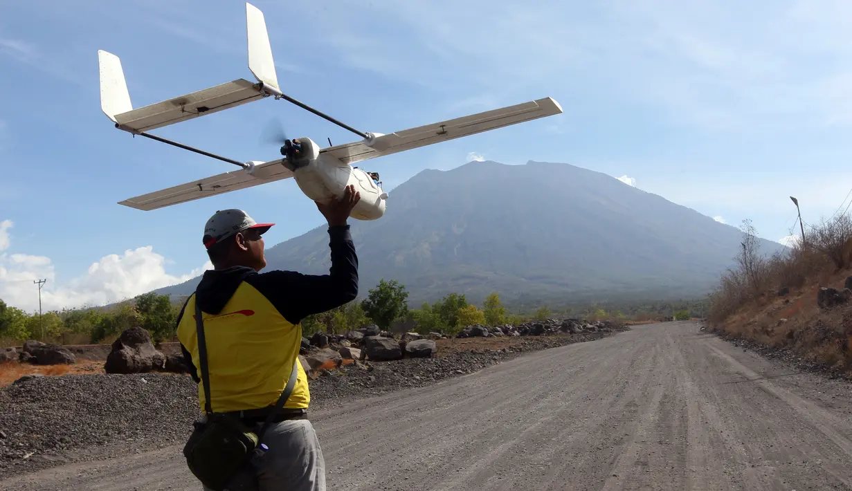 Petugas BNPB menerbangkan drone atau pesawat pengintai tidak berawak, di Desa Kubu, Kabupaten Karangasem, Bali, Rabu (11/10). Tim gabungan menggunakan tiga unit drone untuk melakukan survei sekaligus memantau kondisi Gunung Agung. (AP/Firdia Lisnawati)
