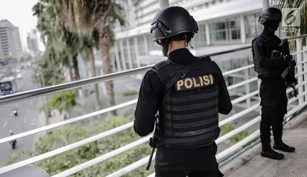 Dua anggota Brimob bersenjata lengkap berjaga di JPO kawasan Bunderan HI, Jakarta, Jumat (11/5). Penjagaan tersebut dilakukan untuk antisipasi kegiatan Aksi 115 Pembebasan Baitul Maqdis yang berpusat di Monas. (Liputan6.com/Faizal Fanani)