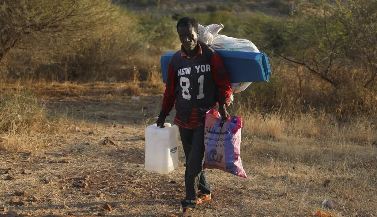 Pengungsi Ethiopia berjalan di wilayah Qadarif, Sudan, Rabu (18/11/2020). Badan Pengungsi PBB mengatakan konflik yang berkembang di Ethiopia telah mengakibatkan ribuan orang melarikan diri dari wilayah Tigray ke Sudan. (AP Photo/Marwan Ali)