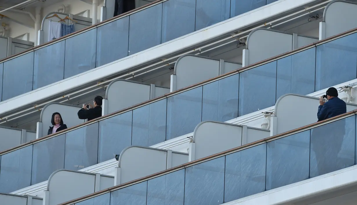 Penumpang foto di balkon kapal pesiar Diamond Princess saat dikarantina Daikoku Pier Cruise Terminal di Yokohama (7/2/2020). Ribuan penumpang terpaksa harus dikarantina setelah seorang penumpang yang turun di Hong Kong pada Januari lalu dinyatakan positif terinfeksi Corona. (AFP/Jiji Press)
