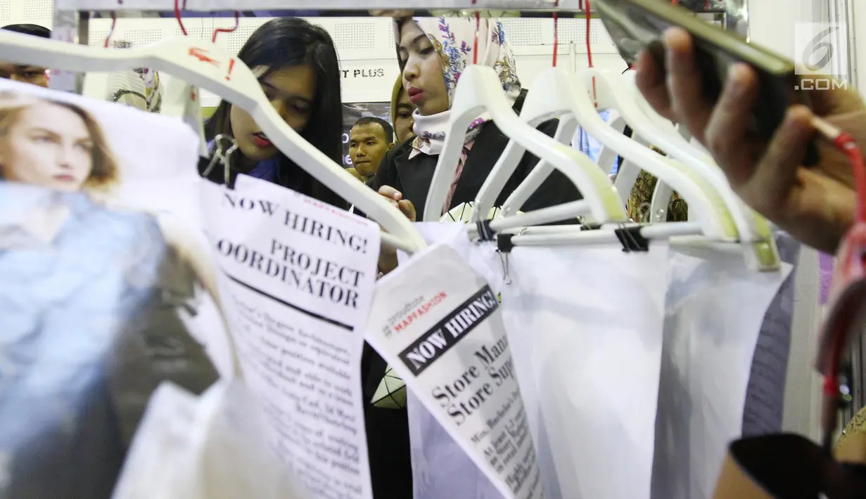 Sejumlah orang membaca-baca informasi perusahaan yang akan dilamar dalam bursa kerja di Jakarta, Rabu (24/1). (Liputan6.com/Angga Yuniar)