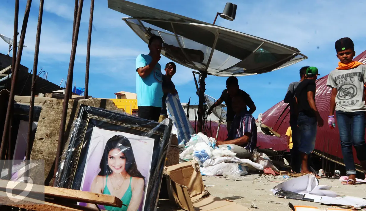 Warga mencari barang yang tersisa di antara puing-puing Pasar Meureudu yang hancur di Pidie Jaya, Aceh, Kamis (8/12). Warga yang memiliki kios di pasar tersebut beramai-ramai mencari barang yang masih dapat diselamatkan. (Liputan6.com/Angga Yuniar)