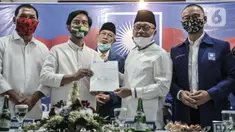Ketua Umum PAN Zulkifli Hasan menyerahkan dokumen dukungan kepada bakal calon Wali Kota Solo Gibran Rakabuming Raka saat menggelar pertemuan di Jakarta, Rabu (12/8/2020). PAN telah resmi memberikan dukungannya kepada Gibran Rakabuming pada Pilkada Solo 2020. (merdeka.com/Iqbal Nugroho)