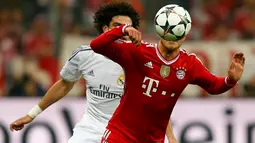 Pepe (Real Madrid-kiri) mencoba merebut penguasaan bola dari Mario Gotze (Bayern Munich) saat laga kedua semifinal Liga Champions yang digelar di Allianz Arena, Munich (30/4/2014). (REUTERS/Ralph Orlowski)