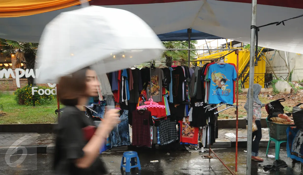 Beberapa pengunjung melintas di antara deretan stand produk pada Festival Kemang yang berlangsung di Jalan Kemang Raya, Jakarta (7/11/2015). Hujan deras disertai angin kencang mewarnai Festival Kemang hari pertama. (Liputan6.com/Helmi Fithriansyah)
