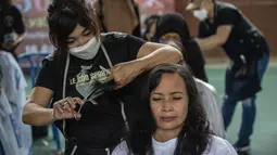 Warga saat potong rambut gratis di Masjid Muhammad Cheng Hoo, Surabaya, Jawa Timur, Senin (18/4/2022). Kegiatan berbagi dalam bulan Ramadhan yang digelar Baksose Suroboyo dan Ngaji Komunitas Salon (Ngasal) Surabaya itu diikuti sekitar 450 orang. (AFP/Juni Kriswanto)