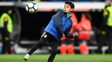 Putra Cristiano Ronaldo, Cristiano Ronaldo Jr berusaha mengontrol bola usai pertandingan antara Real Madrid dan Real Sociedad di stadion Santiago Bernabeu di Madrid, Spanyol (10/2). (AFP Photo/Gabriel Bouys)