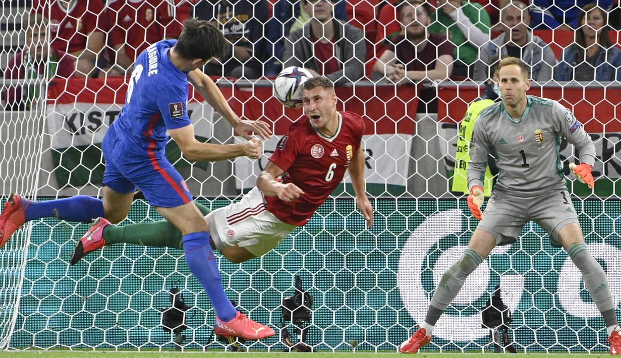 Pemain Hungaria Willi Orban (tengah) menghalau tembakan pemain Inggris Harry Maguire (kiri) pada pertandingan sepak bola Grup I kualifikasi Piala Dunia 2022 di Puskas Ferenc Arena, Budapest, Hungaria, Kamis (2/9/2021). Inggris menang 4-0. (Zsolt Szigetvary/MTI via AP)
