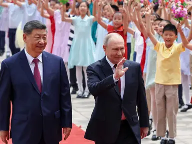 Presiden Rusia Vladimir Putin (tengah) dan Presiden China Xi Jinping menghadiri upacara penyambutan di Balai Besar Rakyat, Beijing, China, pada Rabu 20 Mei 2026. (Alexander Kazakov, Sputnik, Kremlin Pool Photo via AP)