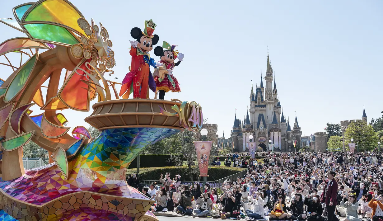 <p>Karakter Disney Mickey dan Minnie Mouse (kiri atas) melambai saat parade siang hari baru di Urayasu, di pinggiran kota Tokyo pada 10 April 2023. (AFP/Richard A. Brooks)</p>