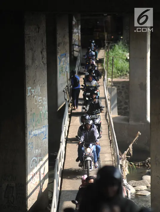 Pengendara motor melewati jembatan Ciliwung yang berada di bawah tol ruas Gadog, Ciawi, Bogor (16/68). Jembatan ini menjadi jalan alternatif bagi pemotor dari kawasan Bogor menuju arah Puncak dan Sukabumi. (Merdeka.com/Arie Basuki)