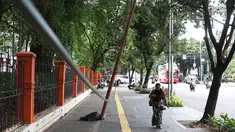 Pejalan kaki melintas di dekat tiang yang miring di Jalan Gedung Kesenian, Jakarta, Jumat (22/2). Keberadaan tiang miring tersebut membahayakan keselamatan pejalan kaki karena kabel yang turut menjuntai hingga ke bawah. (Liputan6.com/Immanuel Antonius)