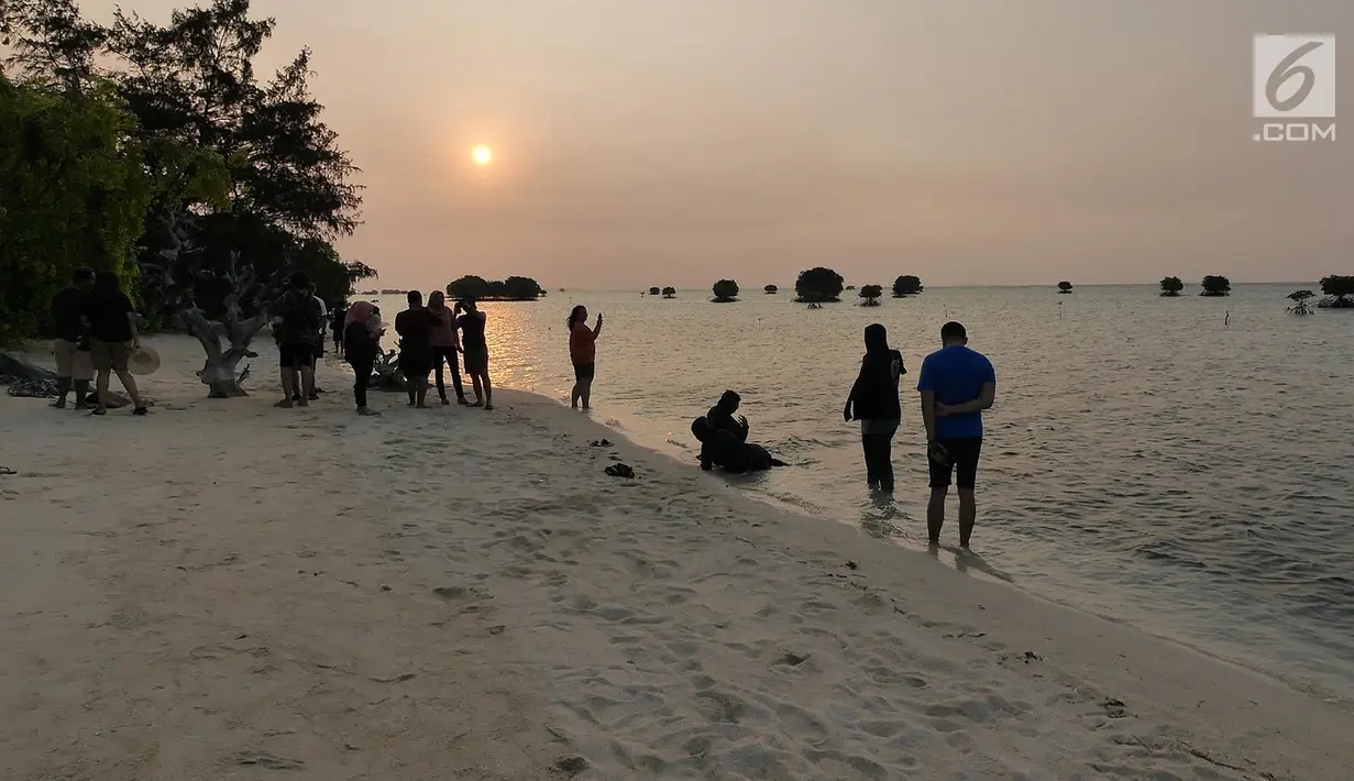 <p>Warga menyaksikan matahari tenggelam (sunset) di Pulau Pari, Kepulauan Seribu, Jakarta pada 3 Agustus 2019. Pulau Pari mempunyai keindahan saat matahari terbenam yang dapat dilihat dari Tanjung Renggae. (Liputan6.com/Herman Zakharia)</p>
