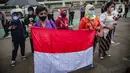 Massa dari Jaringan Pembela Hak Perempuan Korban Kekerasan Seksual membawa bendera Merah Putih di depan Gedung DPR, Jakarta, Rabu (22/12/2021). Mereka mendesak DPR mengesahkan rancangan undang-undang Tindak Pidana Kekerasan Seksual (RUU TPKS) sebagai RUU Inisiatif DPR RI (Liputan6.com/Faizal Fanani)