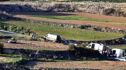Kendaraan polisi dan ambulans terparkir di sepanjang jalan lokasi meledaknya mobil jurnalis investigasi, Daphne Caruana Galizia, di kota Mosta, Malta, Senin (16/10). Galizia tewas seketika dan mobilnya terlempar ke sebuah lapangan. (AP/Rene Rossignaud)