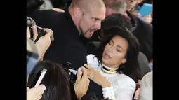 Kim Kardashian terlihat hampir jatuh ke tanah saat tiba-tiba diterjang seorang fans di Paris, (25/9/14). (Dailymail)