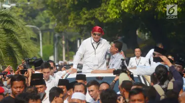 Ketua umum Partai Gerindra Prabowo Subianto mengenakan bandana merah menyapa para pendukungnya usai mendaftarkan bakal calon pasangan Presiden dan wakil presiden di Komisi Pemilihan Umum (KPU), Jakarta, Jumat (10/8).(Merdeka.com/Imam Buhori)