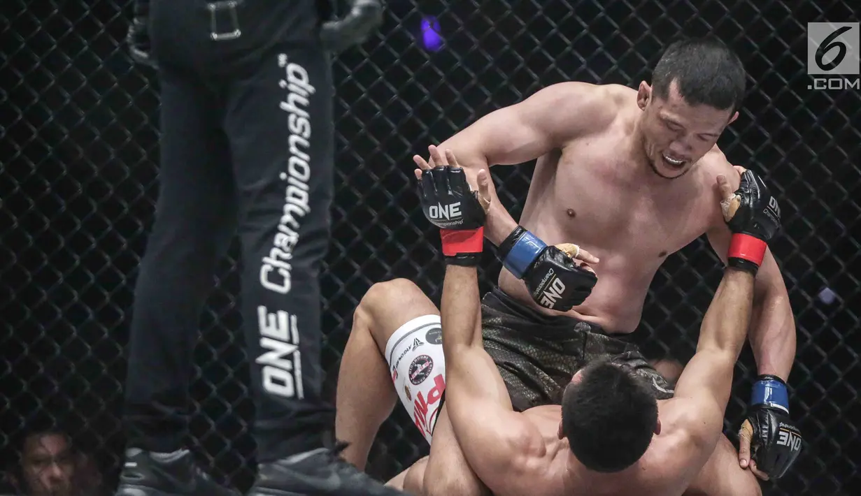 Dua petarung Indonesia Yohan Mulia Legowo (atas) berusaha melakukan pukulan kepada Victorio Senduk (bawah) pada laga One Championship di Jakarta, Sabtu (20/1). Pada laga tersebut Victorio Senduk menang atas Yohan Mulia. (Liputan6.com/Faizal Fanani)