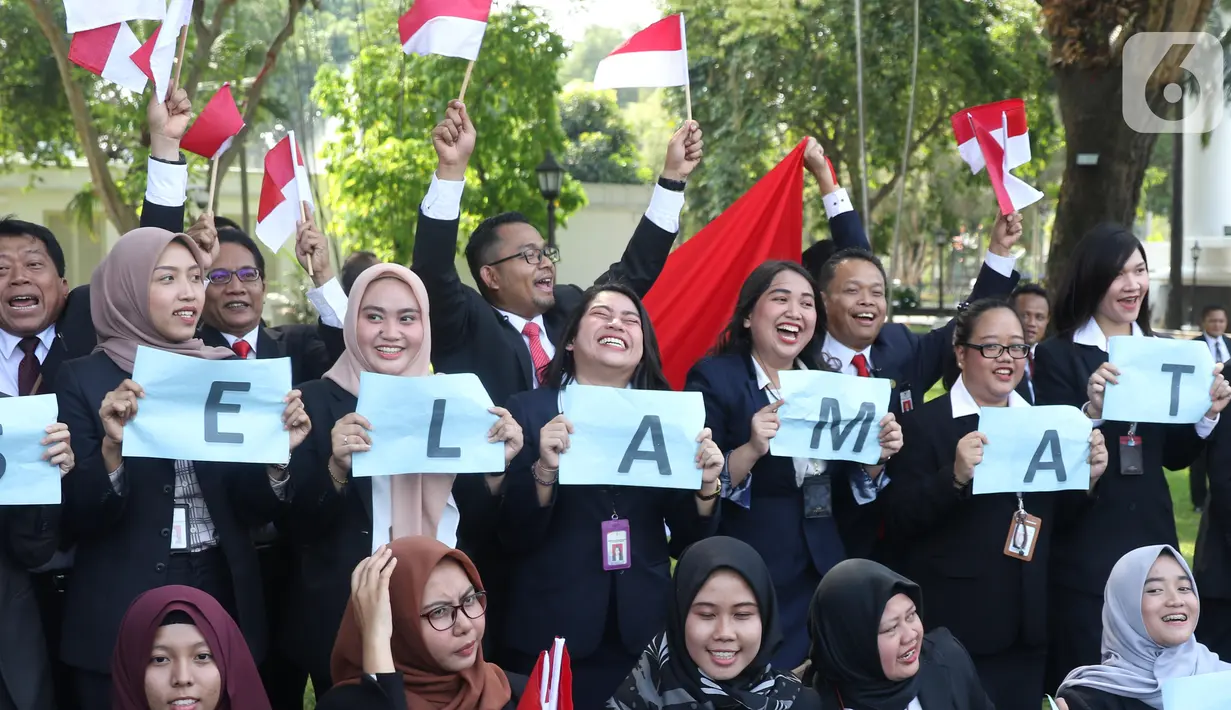 Pegawai Istana mengibarkan bendera merah putih saat rombongan mobil Presiden terpilih Joko Widodo (Jokowi)  melintas menuju gedung DPR di Istana Kepresidenan, Jakarta, Minggu (20/10/2019).  (Liputan6.com/Angga Yuniar)