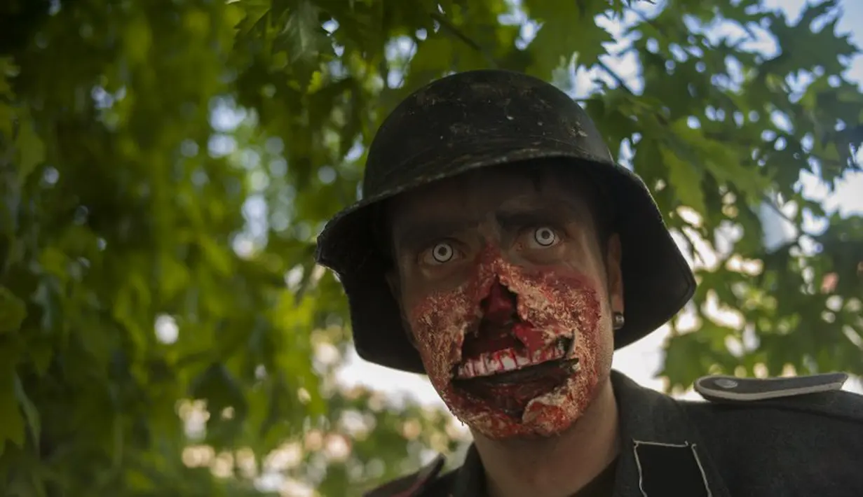  Seorang peserta laki-laki memamerkan hasil karyanya berupa wajah Zombie yang menyeramkan saat Parade Zombie di Praha, Ceko, Sabtu (24/05/2014) (AFP PHOTO/Michal Cizek)