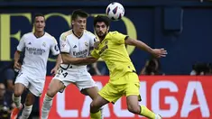 Gelandang Real Madrid #24 Arda Guler dan penyerang Villarreal #09 Goncalo Guedes berebut bola dalam laga jornada 37 La Liga 2023/2024 yang digelar di Estadio de la Ceramica, Senin (20/5/2024) dini hari WIB. (JOSE JORDAN / AFP)
