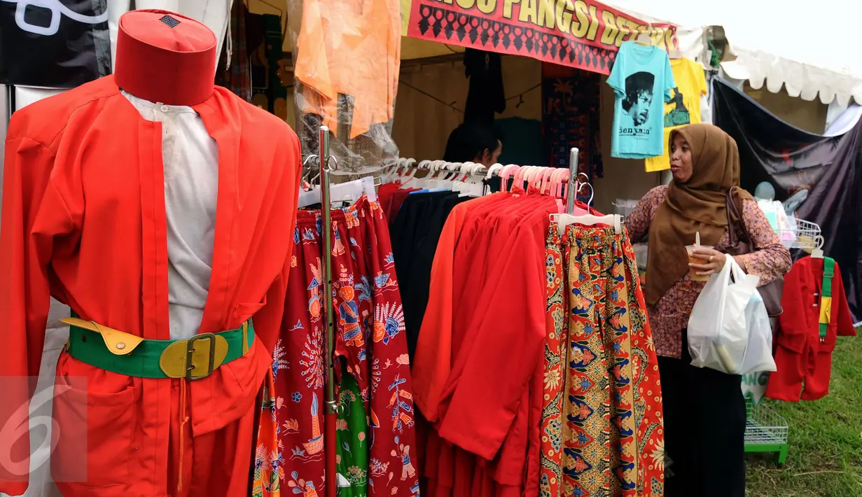 Warga memilih busana khas betawi yang dipamerkan di Pentas Seni dan Budaya Betawi di Kawasan Condet, Jakarta, Sabtu (5/11). Bertema Kampung Condet Berbudaye, pentas seni dan kuliner ini dihelat hingga Minggu (6/11). (Liputan6.com/Helmi Fithriansyah)