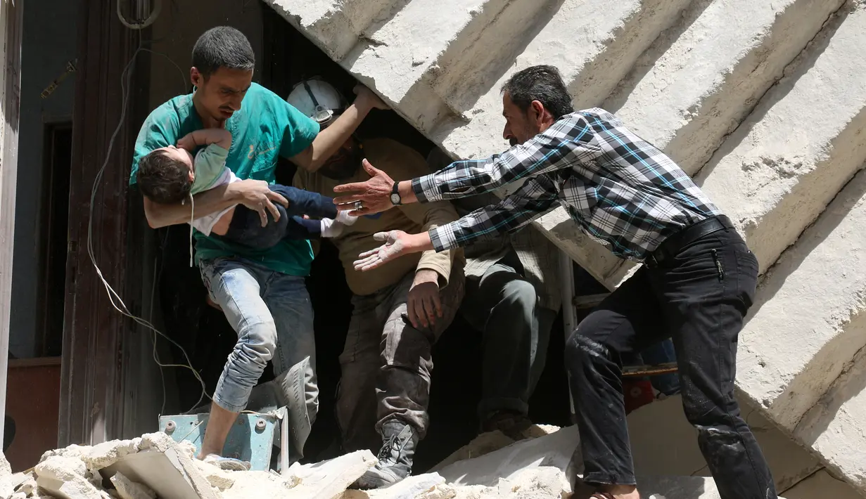 Relawan berusaha menolong bayi  akibat bangunan runtuh setelah serangan udara di kota Suriah bagian utara, Aleppo, Kamis (28/4). Meskipun PBB menetapkan gencatan senjata Februari lalu, jumlah korban tewas terus bertambah. (AFP PHOTO / Ameer ALHALBI)