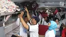 Peserta mudik gratis PT KAI menaruh barang di kereta Brantas Lebaran di Stasiun Senen, Jakarta, Selasa (5/6). Masyarakat dapat mendaftar offline dengan langsung datang ke kantor PT KA Pariwisata di Stasiun Gambir. (Liputan6.com/Angga Yuniar)