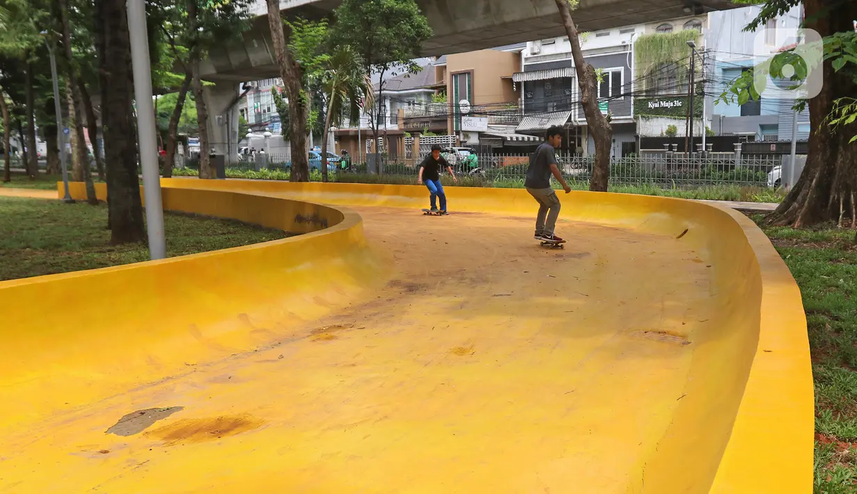 Pengunjung bermain skateboard di Taman Puring, Jakarta, Selasa (14/1/2020). Taman Puring juga menjadi Taman Grande yang berperan sebagai tempat transit serta mendukung ketersediaan Ruang Terbuka Hijau (RTH) di Jakarta. (Liputan6.com/Herman Zakharia)