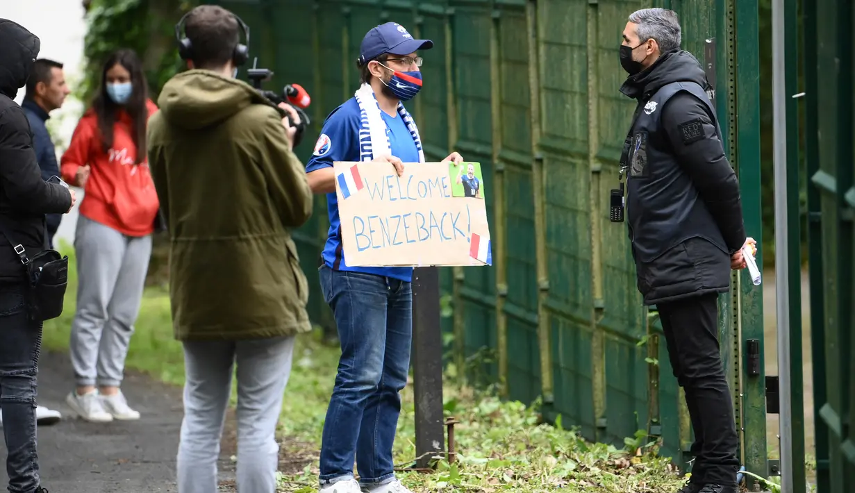 Fans sambil membawa poster menunggu kedatangan Karim Benzema di Pusat latihan Timnas Prancis di Clairefontaine-en-Yvelines, Rabu (26/5/2021). Benzema kembali memperkuat Timnas Prancis setelah enam tahun absen. (AFP/Franck FIfe)
