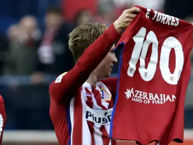Pemain Atletico Madrid, Fernando Torres mengangkat baju bertuliskan 100 gol yang telah dicetaknya bersama Atletico Madrid pada Lanjutan La Liga Spanyol di Stadion Vicente Calderon, Sabtu (6/2/2016).  (EPA/Javier Lizon)