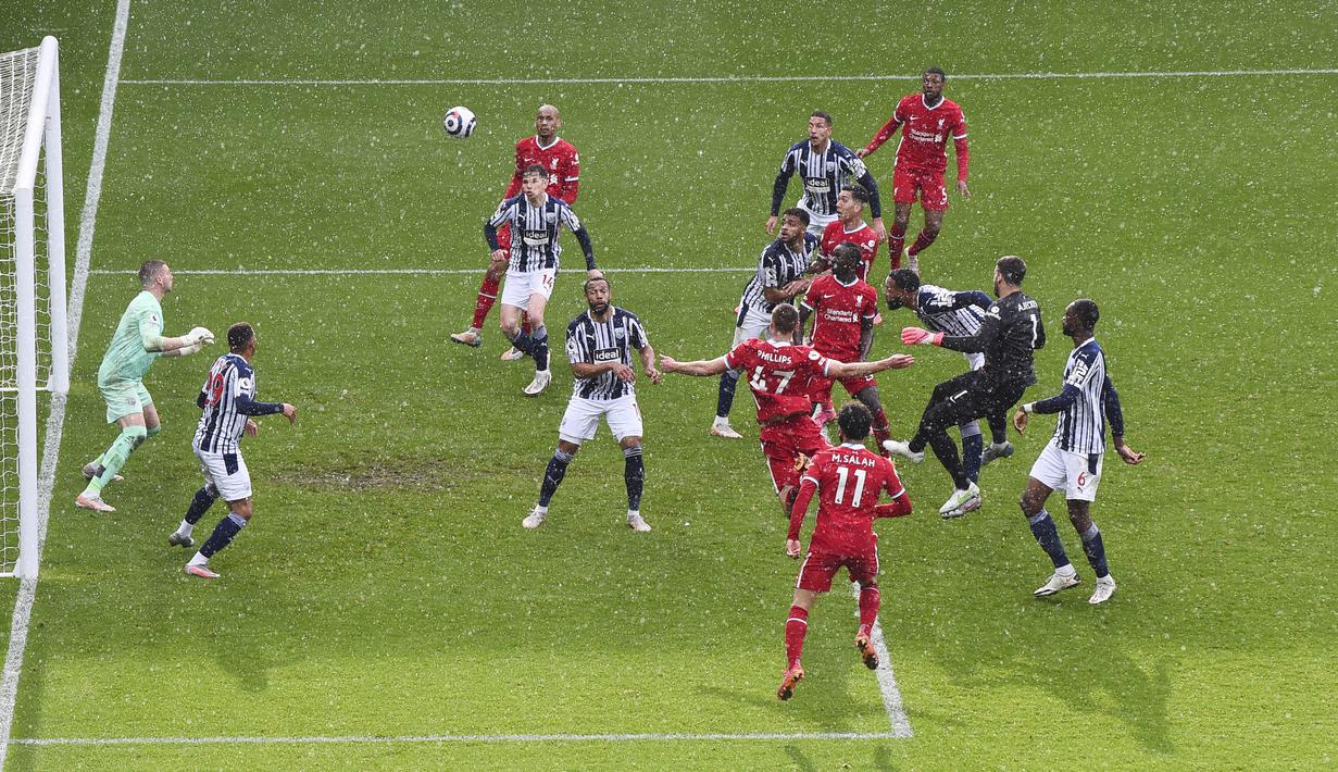 Kiper Liverpool, Alisson Becker, mencetak gol ke gawang West Bromwich Albion dengan tandukan kepalanya pada laga Liga Inggris di Stadion the Hawthorns, Minggu (16/5/2021). Liverpool menang dengan skor 2-1. (Laurence Griffiths/Pool via AP)