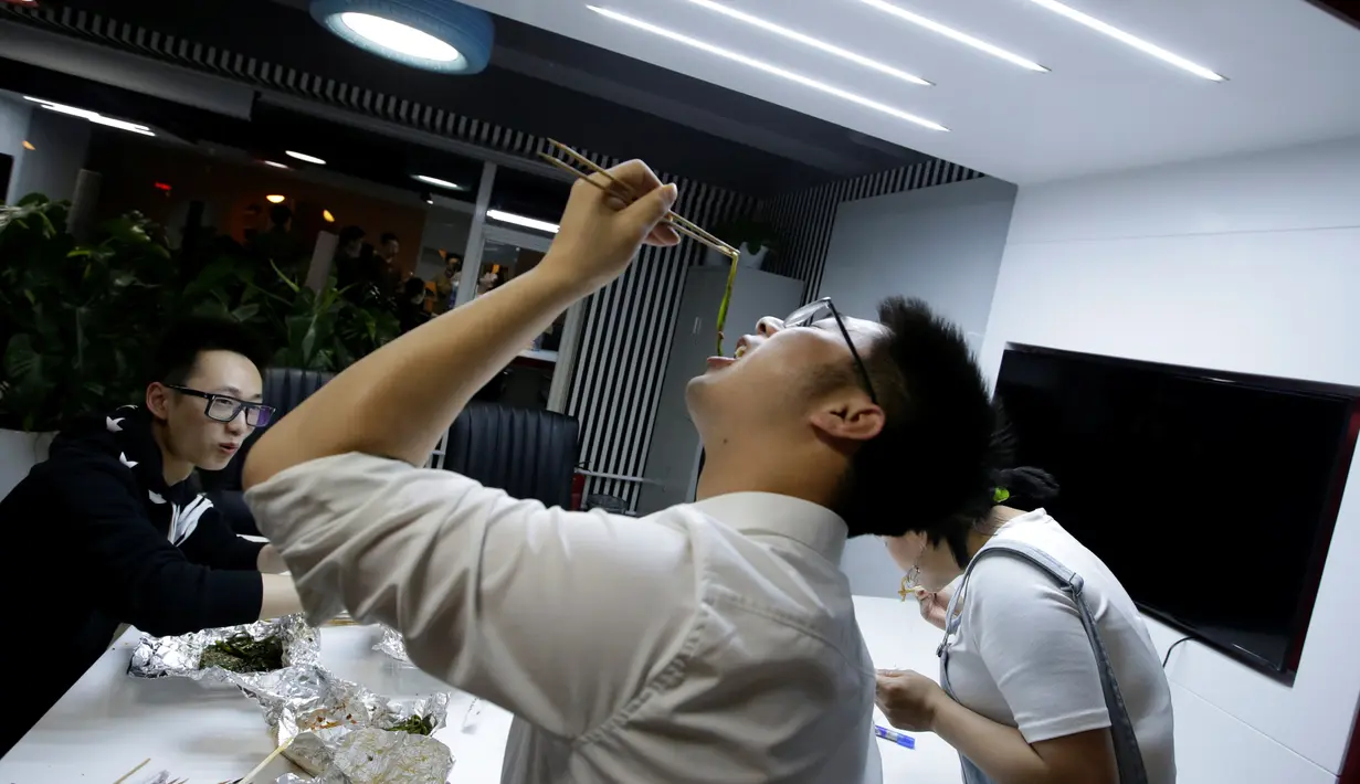 Sejumlah pegawai saat menyantap makan malam di kantornya, di Beijing, China, (21/4). Sejumlah kantor di Beijing menyediakan ruangan kecil yang dikhususkan untuk tidur siang para pegawainya. (REUTERS/Jason Lee)