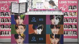Sebuah poster komersial yang menunjukkan anggota boyband K-pop, BTS, terlihat di luar toko lensa kontak di Seoul, Selasa (1/9/2020). Bangtan Boys (BTS) menjadi artis Korea Selatan pertama yang berhasil menempati puncak Billboard Hot 100 dengan lagu Dynamite. (Jung Yeon-je/AFP)