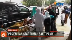 Petugas medis dan keluarga pasien berhamburan keluar gedung, sambil menyelamatkan pasien yang sakit.