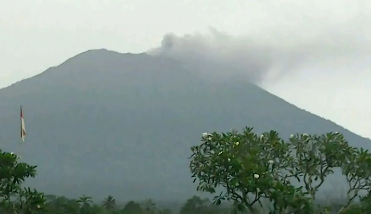 Kondisi Gunung Agung di Kabupaten Karangasem, Bali kembali mengeluarkan awan asap, Selasa (21/11). Masyarakat diimbau untuk berada dalam radius 6 hingga 7 km dari gunung tersebut. (AFP Photo/BNPB)
