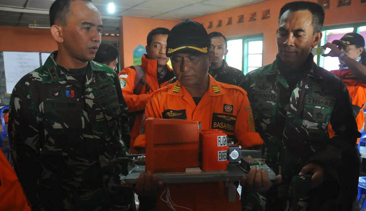 Petugas dari Basarnas memegang sebuah kotak hitam atau Black Box dari helikopter Basarnas yang jatuh di Temanggung, Jawa Tengah (3/7). Helikopter yang membawa 8 orang tersebut jatuh saat perjalanan menuju lokasi letusan kawah Dieng. (AFP Photo/STR)