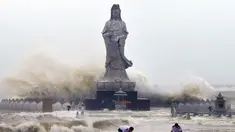 Sejumlah petugas saat menata tanggul didepan patung Bodhisattva Avalokitesvara di Quanzhou,  Cina,  (29/9/2015). (REUTERS/China Daily)