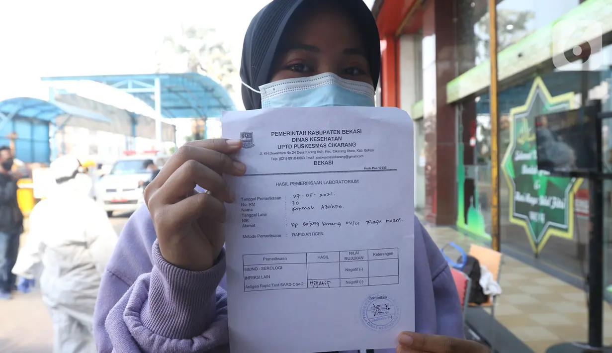 Pedagang memperlihatkan surat keterangan hasil tes di pusat perbelanjaan kawasan Cikarang, Kabupaten Bekasi, Kamis (27/05/2021). Pasca libur lebaran, Forkopimda Kabupaten Bekasi melakukan swab tes antigen kepada 202 pedagang guna mencegah penyebaran COVID-19. (Liputan6.com/Herman Zakharia)