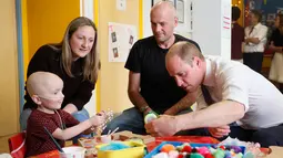 Pangeran William bermain dengan anak pengidap kanker, Charlie Miller saat mengunjungi rumah sakit Royal Marsden di London, Selasa (16/5). Dalam kunjungannya, Pangeran William menghibur sejumlah pasien anak pengidap kanker. (Kirsty Wigglesworth /POOL/AFP)