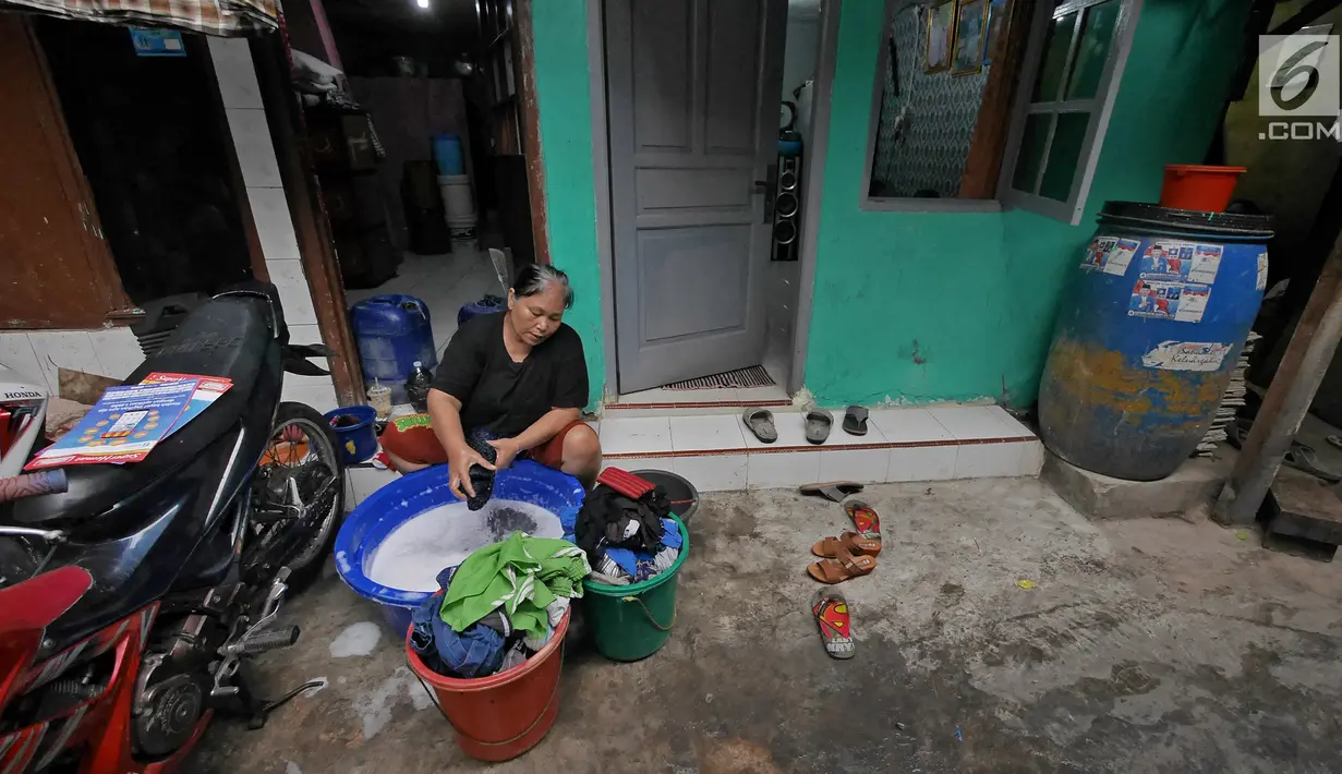 Warga mencuci pakaian di depan rumahnya di Kawasan Muara Baru, Jakarta, Selasa (9/7/2019). Pada saat musim kemarau air sumur tidak mengalir deras, untuk memenuhi air bersih warga dalam sehari mengeluarkan uang Rp. 15.000 untuk membeli enam derigen untuk air bersih. (Liputan6.com/Herman Zakharia)