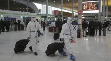 Penumpang dari Taiwan yang mengenakan APD lengkap tiba di Bandara Paris Charles de Gaulle di Roissy, Paris, Senin (1/2/2021). Prancis telah menutup perbatasannya untuk mayoritas negara non-Uni Eropa akibat situasi pandemi dan kekhawatiran penyebaran varian baru Covid-19.  (AP Photo/Francois Mori)
