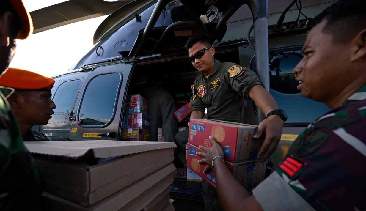 Setiap harinya, pesawat dan helikopter dikerahkan dari Pangkalan Udara (Lanud) Sultan Iskandar Muda untuk menjangkau daerah-daerah yang masih terisolasi. Tampak dalam foto, personel TNI AU memuat pasokan yang akan didistribusikan kepada warga di wilayah terdampak banjir ke dalam helikopter di Pangkalan Udara (Lanud) Sultan Iskandar Muda di Blang Bintang, Aceh Besar pada Kamis 4 Desember 2025. (CHAIDEER MAHYUDDIN/AFP)