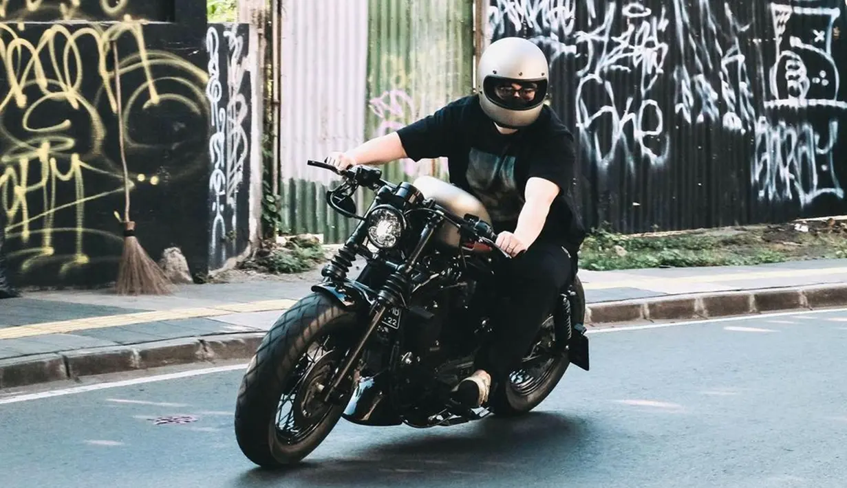 Gaya Chef Arnold dengan motor kesayangannya juga tak lepas dari sorotan publik. Menggunakan kaus dan celana hitam, penampilan santai pria asal Surabaya ini juga tetap terlihat memesona. (Liputan6.com/IG/@arnoldpo)