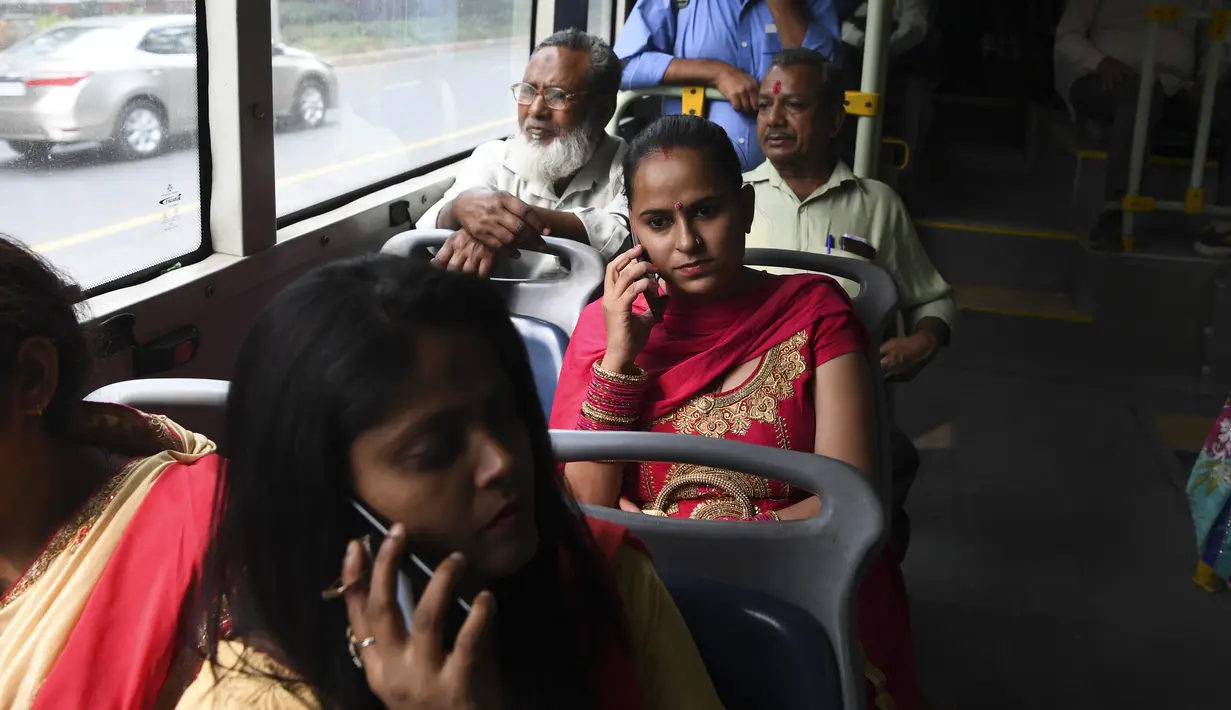 Perempuan bepergian dengan bus  New Delhi Transport Corporation untuk melakukan perjalanan gratis di New Delhi, 29 Oktober 2019. Pemerintahan teritorial ibu kota India, New Delhi, menerapkan kebijakan menggratiskan seluruh rute bus untuk kaum perempuan sejak 29 Oktober. (Sajjad HUSSAIN/AFP)