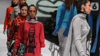 Model disabilitas mengenakan busana rancangan kolaborasi Cotton Ink x Intoart yang digawangi British Council pada Jakarta Fashion Week 2020 di Senayan, Kamis (24/10/2019). Kolaborasi ini menampilkan model disabilitas yang terdiri dari down syndrome, tuna daksa dan tuli. (Liputan.com/Johan Tallo)